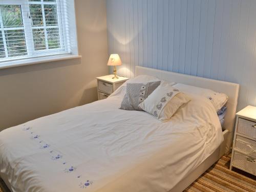 a bed with white sheets and pillows in a bedroom at The Little House in Chacewater