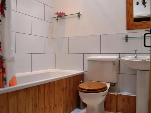 uma casa de banho com um WC, um lavatório e uma banheira em Church Walk Cottage em Kendal