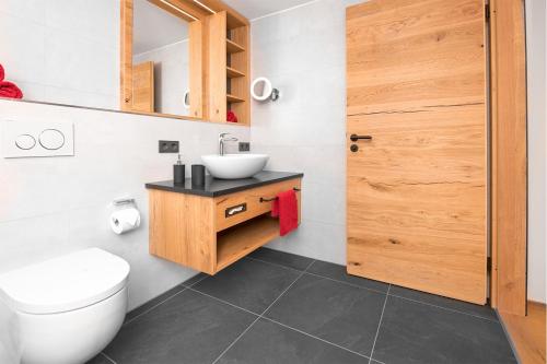 a bathroom with a toilet and a sink at Chalet-Ferienwohnung Sonnenidyll, 51 qm, Wellness/Fitness/Sauna – Bergrödelhof in Feilitzsch