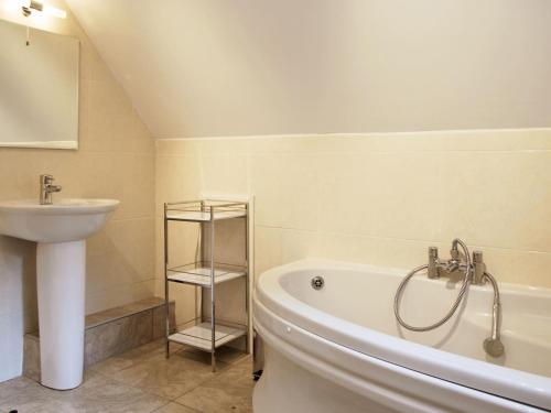 een badkamer met een wastafel, een bad en een wastafel bij Winhill Cottage in Bamford