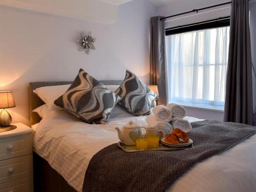 uma bandeja de pequeno-almoço numa cama com ovos e sumo de laranja em Garden View Apartment em Sneaton