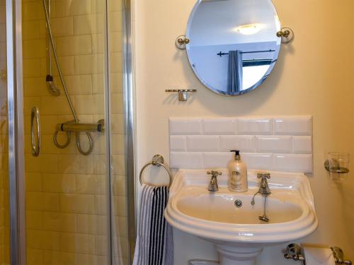 uma casa de banho com um lavatório e um espelho em Garden View Apartment em Sneaton