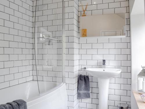 Baño blanco con bañera y lavamanos en Pear Tree Cottage, en Wirksworth