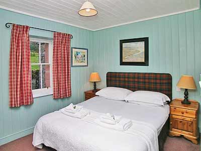 um quarto com uma grande cama branca e uma janela em Marwhin Cottage - Swws em Kirkpatrick Durham