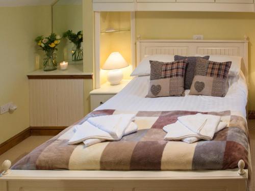 Somerford KeynesにあるMoorhens Cottageのベッド(枕、毛布付)