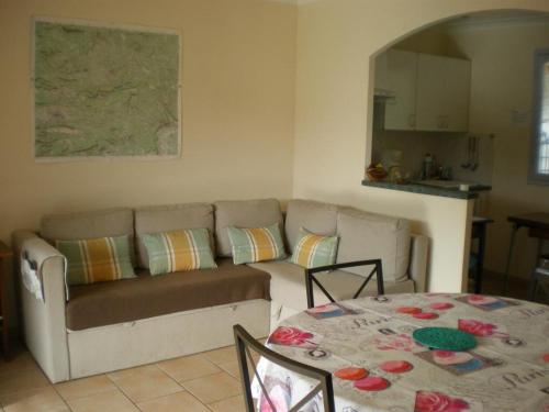 un salon avec un canapé et une table dans l'établissement Jolie maison avec terrasse, au Luc