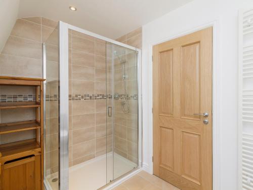 a shower with a glass door in a bathroom at Torfern in Achaphubuil