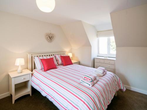 - une chambre avec un lit doté d'oreillers rouges et une fenêtre dans l'établissement Beach Retreat - E5558, à Mundesley