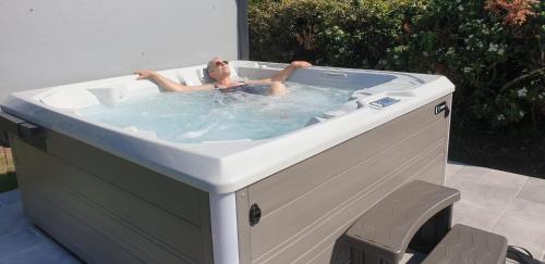 a woman laying in a jacuzzi tub at La Maison Keribin in Moëlan-sur-Mer