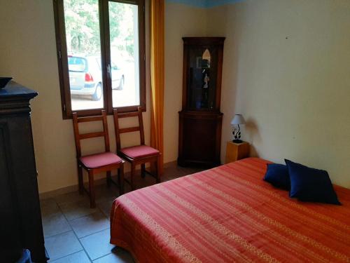 1 Schlafzimmer mit einem Bett, 2 Stühlen und einem Fenster in der Unterkunft Vautrain in Artignosc-sur-Verdon