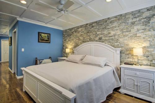 a bedroom with a white bed and a brick wall at Lake-View Osage Beach Resort Home with Game Room! in Osage Beach
