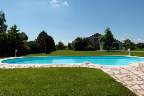 a large swimming pool in the yard of a house at Agora in Foussemagne