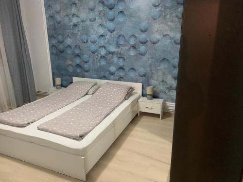 a bedroom with a bed and a blue wall at Confort Apartment in Mediaş
