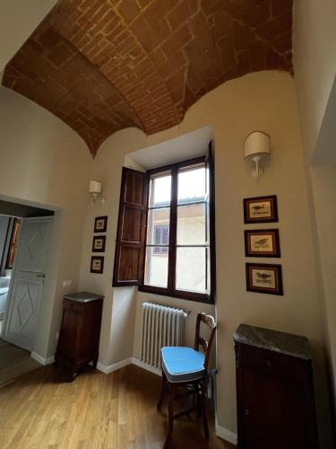 a room with a table and a chair and a window at Maestra Exclusive Chianti House, Tuscany in Poggibonsi