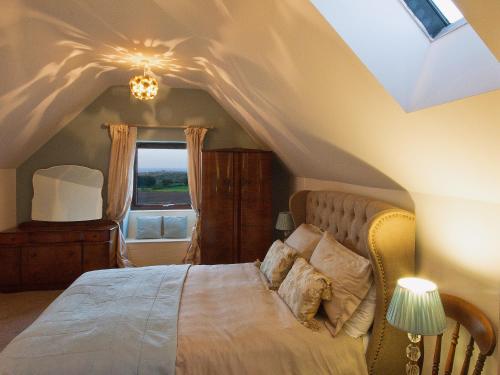 um quarto com uma cama grande e um telhado em Mortar Barn em Stainsacre