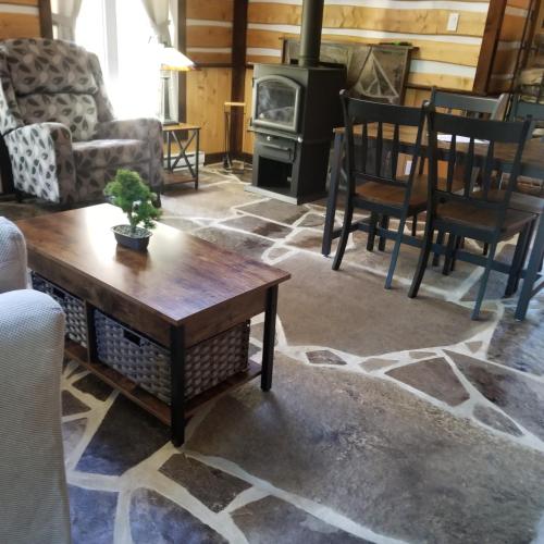 a living room with a table and chairs and a stove at Domaine Rivière Sacacomie in Saint-Alexis-des-Monts
