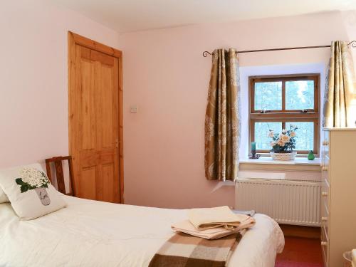 een slaapkamer met een bed en een raam bij The Granary in Lanton