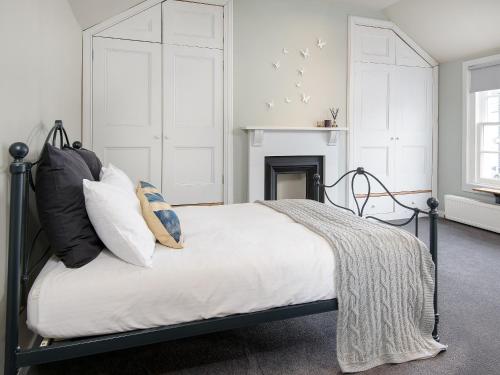 a bedroom with a bed with pillows and a fireplace at Knocktinkle in Gatehouse of Fleet