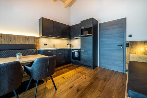 a kitchen with wooden floors and a wooden table and chairs at Gästehaus Mirzl in Schladming