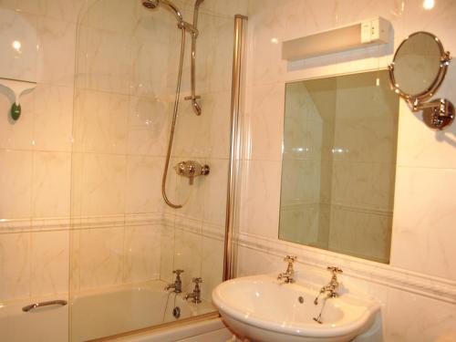 uma casa de banho com um chuveiro, um lavatório e uma banheira em Applecroft em Keswick