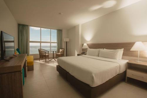 Habitación de hotel con cama, escritorio y TV. en Decameron San Luis - All Inclusive, en San Andrés