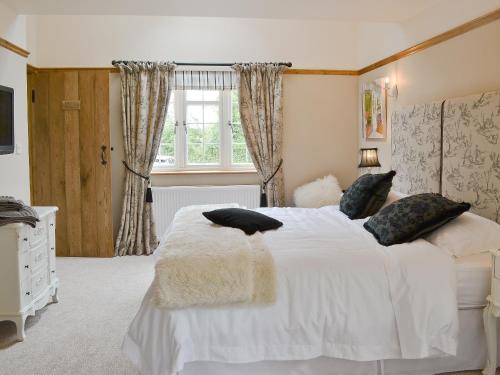a bedroom with a white bed and a window at Pettaugh Lodge in Debenham
