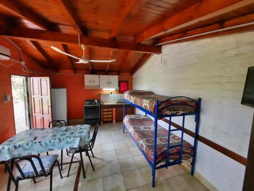 Zimmer mit einem Tisch und einem Etagenbett in der Unterkunft Cabañas Berta y Jorge in Cacheuta