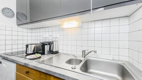 a kitchen with a sink and a counter top at HOMEY LIBERTA - Hypercentre / Proche tram / Balcon privé / Wifi & Netflix in Annemasse