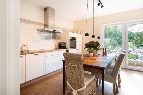 a kitchen with a wooden table and a dining room at Ferienhaus DHH SKILLEHUS in Tating