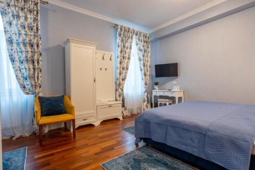 a bedroom with a bed and a chair and a desk at Vila Missy in Deva