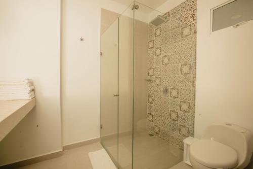 a bathroom with a toilet and a glass shower at Decameron San Luis - All Inclusive in San Andrés