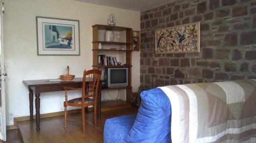 - une chambre avec une table, un lit et un bureau dans l'établissement Le gite la licorne, à Saint-Raphaël