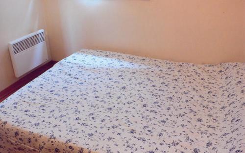 une chambre avec un lit avec une couette fleurie dans l'établissement Le gite la licorne, à Saint-Raphaël