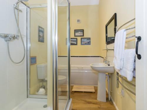 a bathroom with a shower and a sink and a toilet at Ingleby Barn - 27946 in Battersby