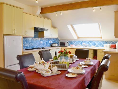 a kitchen with a table with tea sets on it at Ellen Cottage in Ireby