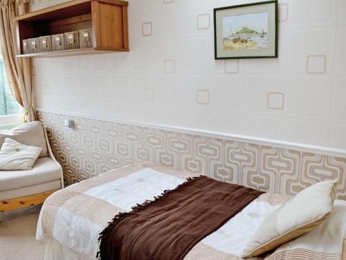 een slaapkamer met een bed en een foto aan de muur bij Hydrangeas in Malborough