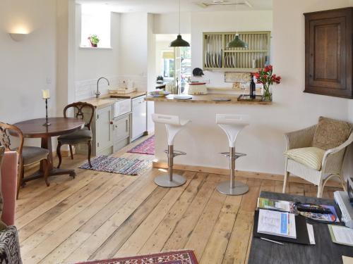 a kitchen with a wooden floor and a table at Evie Rose Cottage in Elsenham