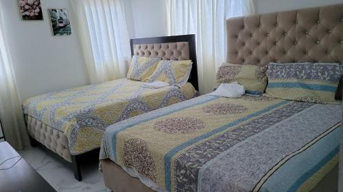 1 Schlafzimmer mit 2 Betten und einem Kopfteil in der Unterkunft Madome Aparta Hotel in Pedernales