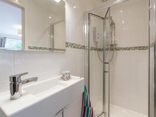 een witte badkamer met een wastafel en een douche bij Sheeoch in Comrie