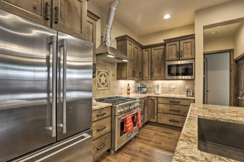 a kitchen with wooden cabinets and a stainless steel refrigerator at half Mi to Dtwn Golden Gem with Patios! in Golden