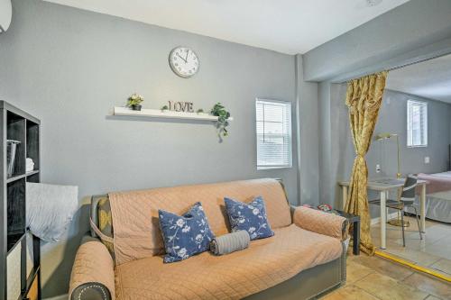 a living room with a couch and a clock on the wall at North Las Vegas Studio with Fire Pit 10 Mi to Strip in Las Vegas