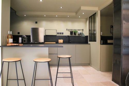 une cuisine avec deux tabourets de bar et un comptoir dans l'établissement Gîte LES TERRASSES 3, à Villard-de-Lans