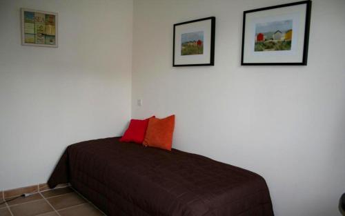 une chambre avec un lit avec deux tableaux au mur dans l'établissement Belle villa le bastidon, à Saint-Raphaël