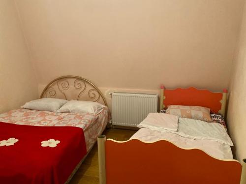 a bedroom with two beds with red and white sheets at Sweethome in Batumi