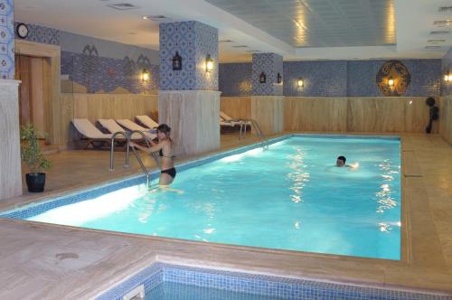 dos personas en una piscina en un hotel en Taksim Gonen Hotel, en Estambul