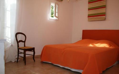 a bedroom with a bed and a chair and a window at Gite au domaine de siouvette in La Môle