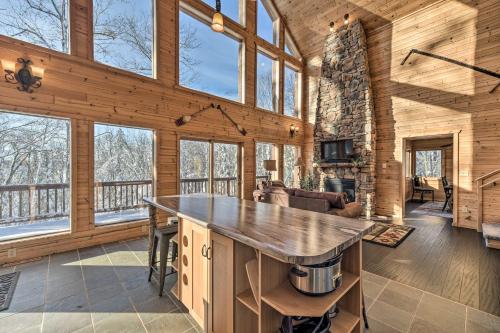 a kitchen and living room of a log cabin with windows at Paddle Ready Hayward Lake View Retreat with BBQ in Hayward