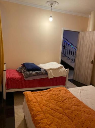 a bedroom with two beds and a door to a balcony at Sweethome in Batumi