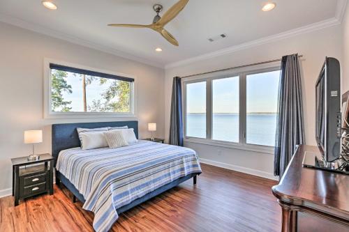 Schlafzimmer mit einem Bett, einem Schreibtisch und Fenstern in der Unterkunft Beautiful Waterfront Getaway with Dock! in Abbeville