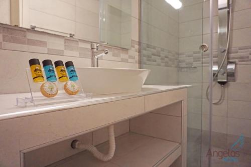 La salle de bains est pourvue d'un lavabo et d'une douche. dans l'établissement Angelina Hotel, à Ormos Panagias